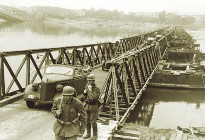 Немецкие солдаты переходят реку Висла по мосту, построенному инженерами вермахта.