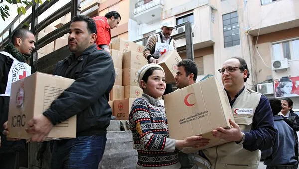 Добровольцы Сирийского Арабского Красного Полумесяца и местные жители разгружают продовольственную помощь. Архивное фото