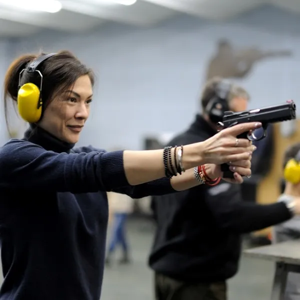 женщина тренируется спортивной стрельбе