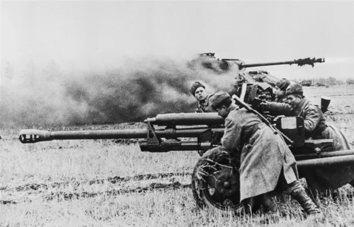 Красноармейцы во время боя перекатывают пушку ЗиС-3 возле подбитого и горящего немецкого танка Pz.Kpfw. V «Пантера» в Восточной Пруссии. 3-й Белорусский фронт.
