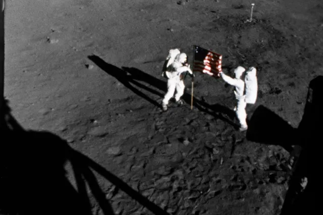 Нил Армстронг (слева) и Эдвин Олдрин устанавливают на Луне флаг США.